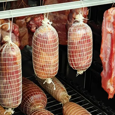 Средние куски мяса обвязаны и подвешены. Крупные - на решетках